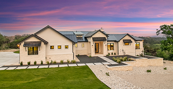 Modern custom home exterior with luxury outdoor living area and scenic Hill Country surroundings